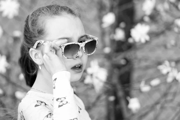 Küçük kız yaz doğasında güneş gözlüğü takar. — Stok fotoğraf