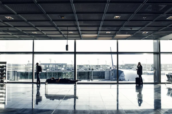 People with luggage waiting hall of airport at window glass — Stock Photo, Image