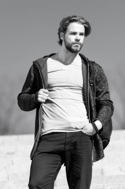 Güneşli açık, moda giyim, sakallı adam. Mavi gökyüzü, perspektif maço kürsüye. Perspektif, gelecek, özgürlük. Erkek moda ve stil