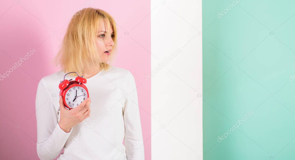 What time is it. Lack of sleep bad for health. Oversleeping side effects too much sleep harmful. Girl drowsy tousled hair just woke up holds alarm clock. Bad sleep habits effects on life, copy space