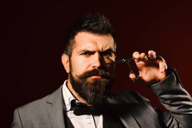 Uzun sakallı adam çelik makas tutuyor..