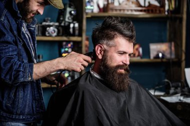 Kuaför saç kesme makinesi ile sakallı adam berber arka plan saç kesimi üzerinde çalışır. Hipster istemci Başlarken saç kesimi. Hippi saç modeli kavramı. İstemci ense üzerinde kırpma makası kesme saçlı berber