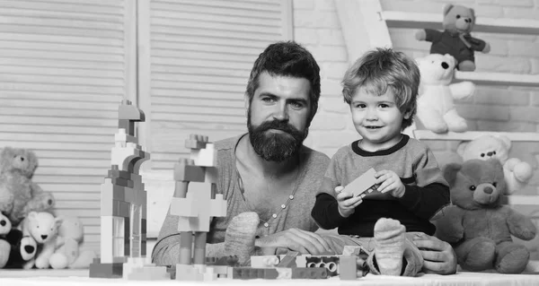 Padre e hijo con caras sonrientes crean construcciones coloridas —  Fotos de Stock