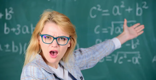 Il maestro si interroga sul risultato. Risolvi il compito di matematica. Sai come risolvere quel compito. Istruzione scolastica conoscenze di base. Donna indossare occhiali intelligente insegnante in classe lavagna sfondo, primo piano — Foto Stock