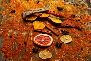 Ahşap doku baharat kaşıklarla. Baharat tüm ahşap yüzey üzerinde dağınık. Tarçın, öğütülmüş kırmızı biber ve curcuma toz ve mutfak otlar dolu kaşık masa üzerinde dağınık. Baharat kavramı