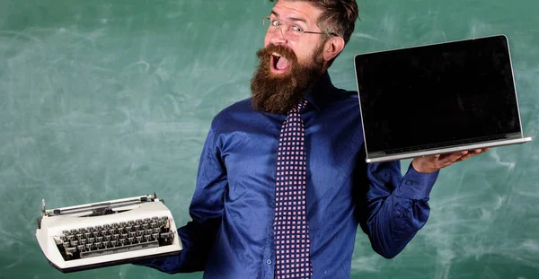 Moderno invece obsoleto. Insegnante hipster barbuto detiene macchina da scrivere e laptop. Insegnante che sceglie approccio didattico. Digitale contro retro. Le moderne tecnologie ne traggono vantaggio. Scegli il giusto metodo di insegnamento — Foto Stock