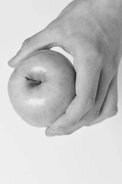 Concepto de alimentación y dieta. Mano masculina sostiene manzana verde claro . — Foto de Stock