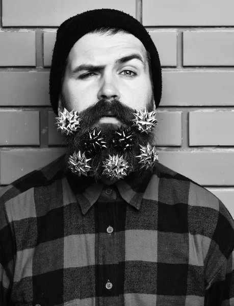 Bearded man, brutal caucasian squinting hipster with gift decoration stars