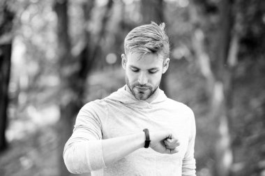 Adımölçer cihazıyla atletizm eğitimi. Meşgul yüz kontrolü yapan sporcu, spor takip cihazı, doğa geçmişi. Fitness takip cihazı ya da adım sayacı olan bir atlet. Spor aleti kavramı