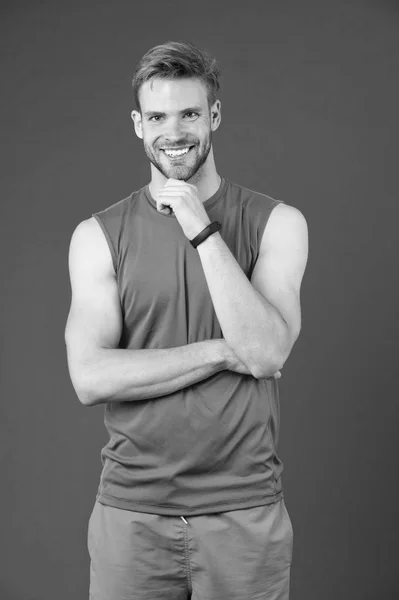 Homem feliz com smartwatch esporte em fundo violeta. Esportista sorrir em colete laranja e shorts. Acessório de moda para treinamento. Nova tecnologia para um estilo de vida saudável. Desporto ou fitness e bem-estar — Fotografia de Stock