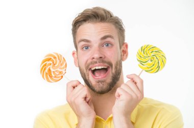 Etkileyici gerçek şeker besin. Yakışıklı sakallı adam lolipop şeker tutuyor. Lolipopu olan adam şaşırmış görünüyor. Sağlıklı beslenme ve diyet konsepti. Şaşırtıcı etki şekerim. Tatil tatlıları.