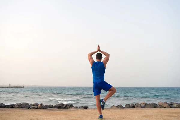 Trouvez l'équilibre et unissez-vous à la nature. La pratique du yoga aide à trouver l'harmonie et l'équilibre. Homme pratiquant yoga mer plage fond. Un endroit paisible. Atteint la tranquillité d'esprit. Concept de sérénité et harmonie — Photo