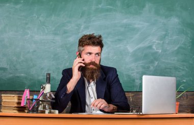 Arayacağım. Okul Öğretmen çağrı cep telefonu sit sınıf kara tahta arka planı süre. Öğretmen adam konuşma cep telefonu sakallı. Çağrı meslektaşım tavsiye isteyin. Pedagog arkadaşları temas tutmak