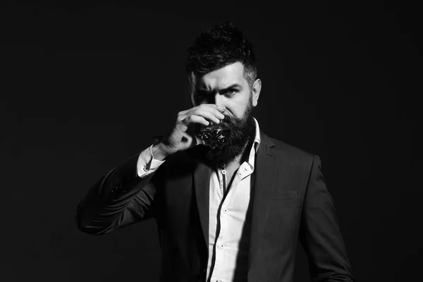 Connoisseur com barba e bourbon ou uísque sobre fundo preto — Fotografia de Stock