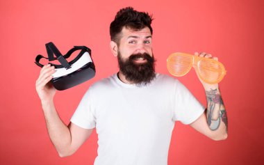 Alternatif gerçeklik. Sanal gerçeklik kulaklık ve kırmızı zemin üzerine çok güneş gözlüğü sakallı adam hippi. Adam ne tercih gerçek veya sanal karar. Gerçeklik ve Vr tercihi