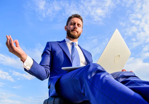 Stay positive reply to client. Work online can be annoying. Entrepreneur find minute relax and meditate. Communication online full of bullying. Businessman formal suit with laptop meditating outdoors