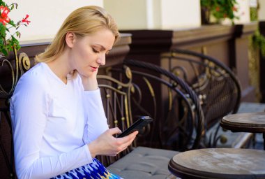 Kime ben metin gerekir. Kadın sakin yüz smartphone kafe Teras kentsel arka plan ile otur. Kız boş zaman harcamak kiminle ortak arıyorum. Bayan kafede vakit geçirmek bir şirket için arıyorum