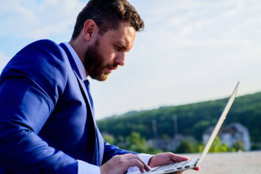 Sosyal medya pazarlama uzmanı mavi gökyüzü arka çalışır. Online itibar ipuçları artırın. İşadamı sörf internet veya yanıt e-postalar ile dizüstü bilgisayar açık havada oturup süre. Markanızın online itibar