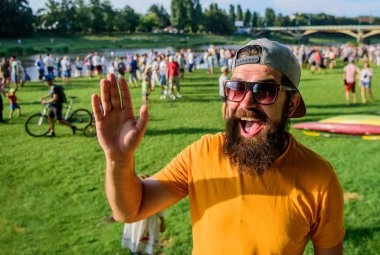 Kentsel olay kutlama. Hippi Cap olay piknik fest veya Festivali arkadaşı karşılamak mutlu. Adam hipster kalabalık insan sallanan el yeşil nehir arka plan önünde sakallı. Memnun oldum