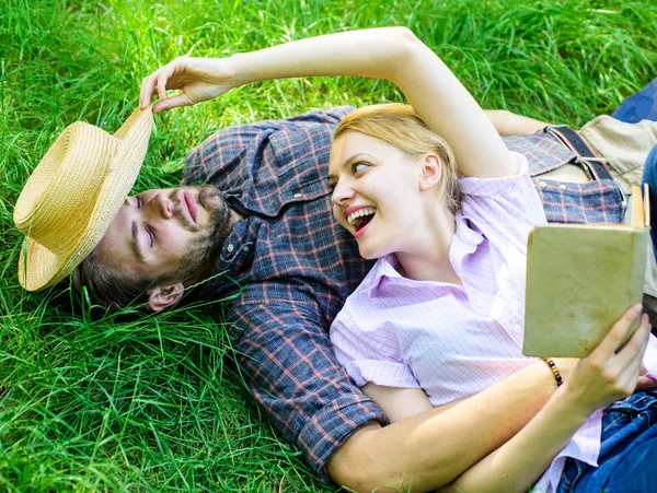 Quelques âmes sœurs à un rendez-vous romantique. Homme et fille s'allongeaient sur l'herbe relaxante. Couple amoureux passer le livre de lecture de loisirs. Famille couple romantique profiter des loisirs avec de la poésie ou de la littérature fond d'herbe — Photo