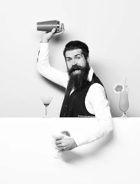 Uzun sakal ve bıyık yakışıklı sakallı barmen shaker tutan komik yüzünde şık saçlı ve vintage süet deri yelek mor yeşil studio arka plan üzerinde alkollü kokteyl yapılan — Stok fotoğraf