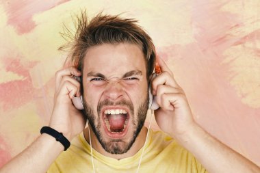 Amerikan yakışıklı adam kulaklıklarla sakallı. Neşeli genç dj kulaklık üzerinden dinleme şarkıları. Smartphone ile mavi gözlü şık hippi. Avrupa adam var eğlenceli zaman. Müzik lifestyl