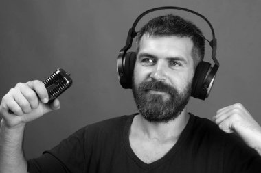 Adam mikrofonu yeşil arka planda tutuyor. Rahatlayın ve müzik konsepti.