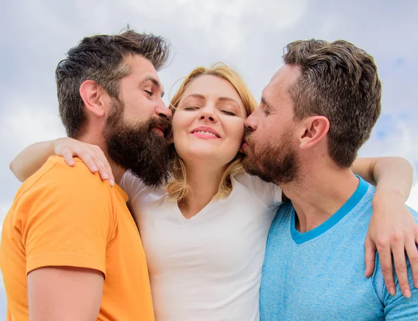 Guía definitiva evitando la zona de amigos. Todo lo que debe saber evitar la zona de amigos empezar a salir. Los hombres besan a la misma chica en las mejillas. Le gusta la atención masculina. Chica abrazos con dos chicos. Relaciones amistosas —  Fotos de Stock