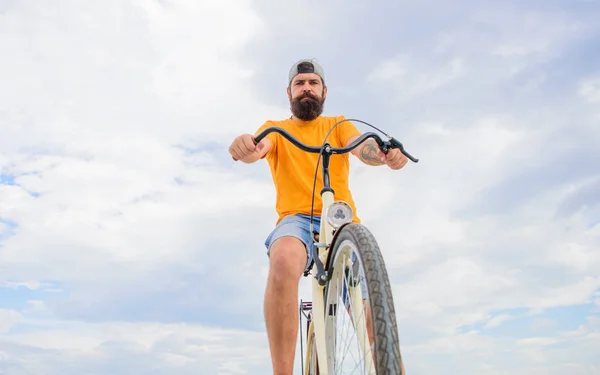 Człowiek Brodaty hipster przejażdżki rowerowe dolnej widok na tle nieba. Porady mechanika rowerów. Koła rowerowe, poradnik. Sprawdź czy punkt obsługi rowerów w bezpiecznej podróży. Zachować koła właściwych warunków — Zdjęcie stockowe