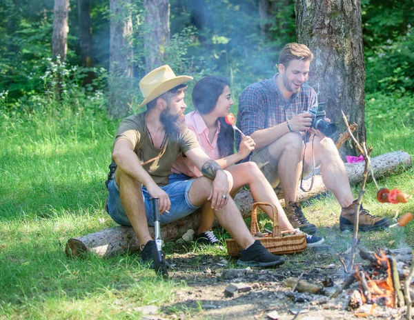 Un picnic estivo. Turisti escursionisti rilassanti mentre hanno spuntino pic-nic. Picnic con gli amici nella foresta vicino al falò. Escursionisti rilassanti durante lo spuntino. Compagnia amici avendo escursione picnic natura sfondo — Foto Stock