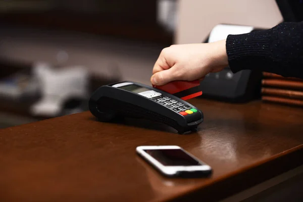 Male hand puts bankcard into reader on defocused background