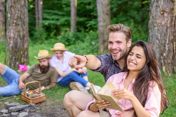 Couples spend time outdoors on sunny day. Youth on picnic or hike relaxing and having fun. Pleasant weekend. Couples tourists rest forest. Couples or families having great time relaxing near campfire