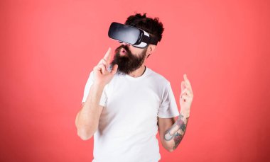 Adam kırmızı zemin üzerine sanal gerçeklik kulaklık ile hippi sakallı. VR oyun çekim. Birinci kişi ateş gösterir nasıl bağımlılık Vr olabilir. Adam el hareketi olarak silah oyun shooter oyun Vr gözlük