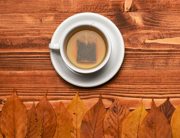 Warme drank op de schotel op houten achtergrond — Stockfoto