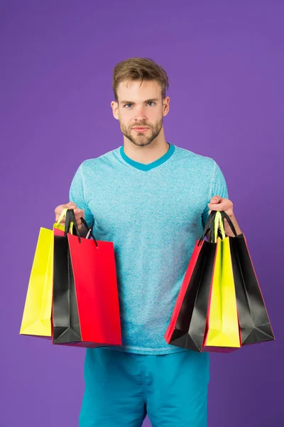 Chancen ergreifen. Ein bärtiges Gesicht hält Einkaufstüten in der Hand. Guy kaufte viel sportliche Kleidung und Accessoires. Mann beim Einkaufen am Schwarzen Freitag. Guy kaufte viele Artikel mit Rabatt. Saisonales Verkaufskonzept — Stockfoto