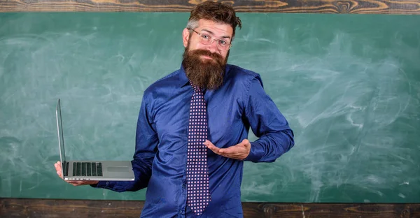 Hipster lärare förvirrade uttryck rymmer laptop. Undervisning problem med hjälp av modern teknik. Lärare bearded man ihop arbetet med modern laptop chalkboard bakgrund. Avstånd utbildningsfrågor — Stockfoto