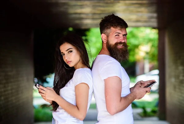 Couple chatting smartphones. Communication problems. Virtual relationship. Girl attractive brunette bearded hipster man stand back to back porch underground crossing. Couple ignore real communication