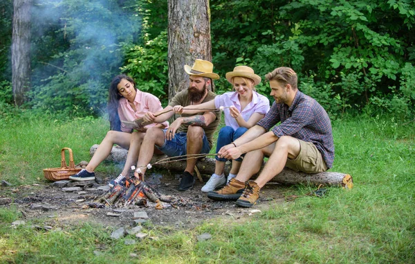 Idyllic weekend. Friends enjoy weekend barbecue in forest. Group friends spend leisure weekend hike picnic forest nature background. Company friends spend great time picnic or barbecue near bonfire