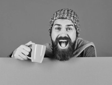 Adam yeşil ve cyan arka planda turuncu bardağı tutuyor