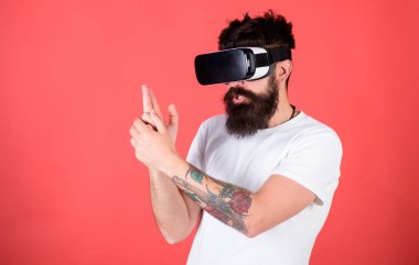 En iyi shooter Vr. Man için kırmızı bir arka plan üzerinde sanal gerçeklik kulaklık ile hippi sakallı. Birinci kişi ateş gösterir nasıl bağımlılık Vr olabilir. Adam el hareketi olarak silah oyun shooter oyun Vr gözlük