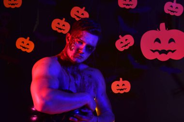 Yüzünde ve göğsünde kan olan adam kaslarını gösteriyor..