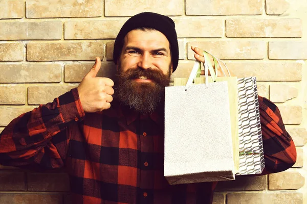 Bärtiger brutaler kaukasischer Hipster mit Schnurrbart hält Einkaufspakete in der Hand — Stockfoto