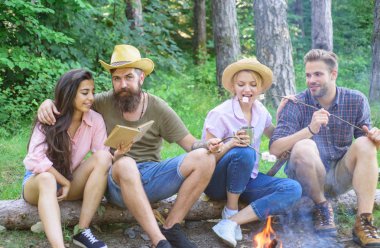Yürüyüşçüler yemek ve dinlenmek için hızlı piknik düzenledi. Yürüyüşçü Orman Doğa arka planda boş zaman harcamak. Gençlik hiking tatil. Piknik fikirler zammı. Kamp ateşi gıda kavurma bekleme sırasında rahatlatıcı yakınındaki yürüyüşçü oturmak
