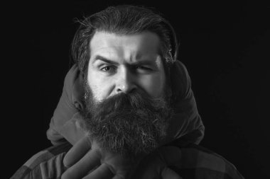 Yakışıklı sakallı adam ya da damalı gömlekli adam ciddi yüzünde şık bıyıklı ve sakallı, süslü sevgililer günü yastığı siyah arka planda kırmızı kalp yastığı.