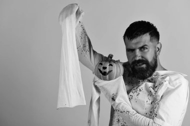 Cadılar Bayramı ve mutlu tatil kavramı. Sakallı adam kabak tutar