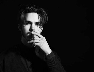 Mavi tişörtlü yakışıklı, şık saçlı, ciddi yüzlü, siyah stüdyo arka planında puro içen, fotokopi çeken adam..