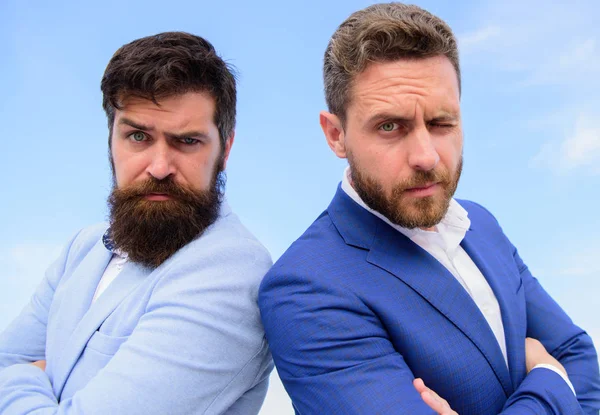 Erkekler resmi takım elbise sırt sırta mavi gökyüzü arka plan ayakta. Kendine güvenen girişimciler patronlar. Nasıl iş ortağınız ile güven kurmak. Avukat Ajansı. İş ortağı güveneyim işaretidir