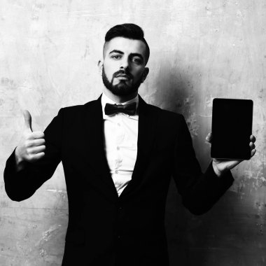 Adam tableti seviyor. Genç sakallı hoparlör yeni cep cihazını sunar ve onaylar. Eski model bej arka plan ve alet reklamları konsepti..