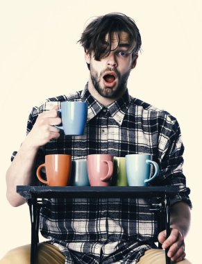 Beyaz arka planda izole edilmiş bardakları tutan yakışıklı adam.