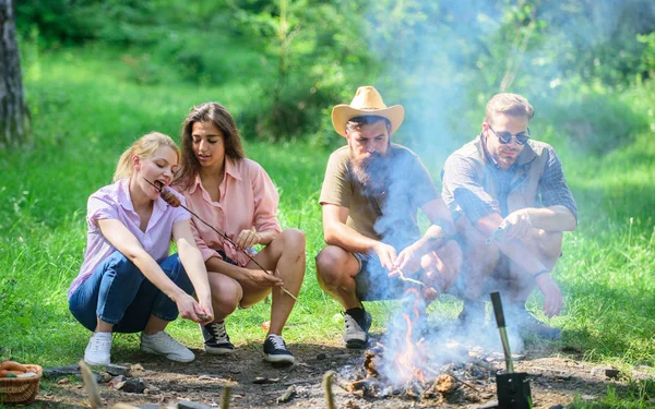 Friends prepare roasted sausages snacks nature background. Company hikers at picnic roasting sausages on sticks. Camping traditional meal prepared on fire with smoky aroma. Take a break to have snack — Stock Photo, Image